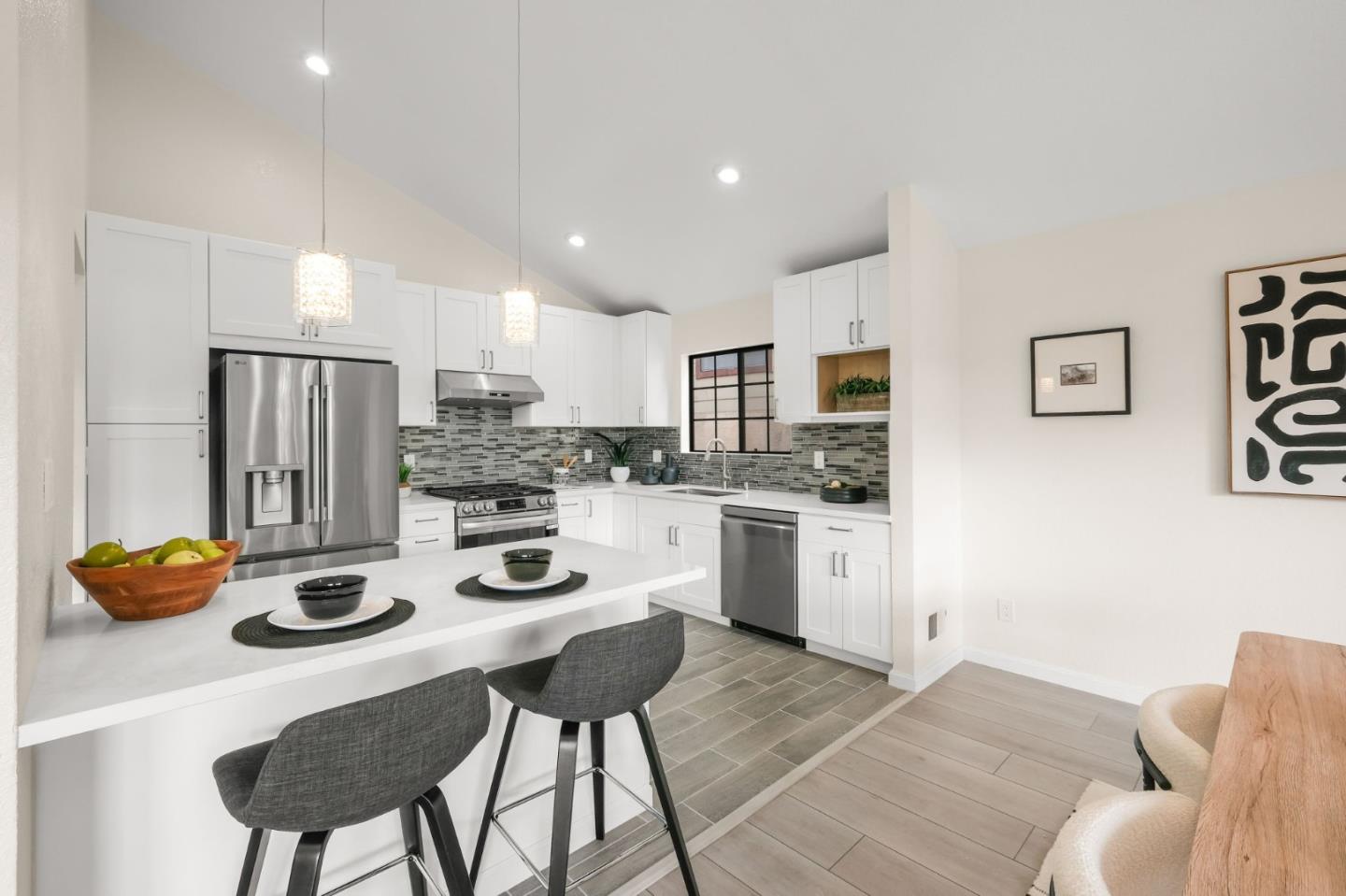 415 C Street Colma, CA 94014 - Photo 20 of 45 a kitchen with stainless steel appliances granite countertop a stove a refrigerator a dining table and chairs
