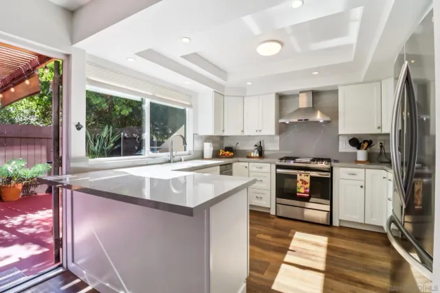 a kitchen with kitchen island granite countertop a sink stove and refrigerator