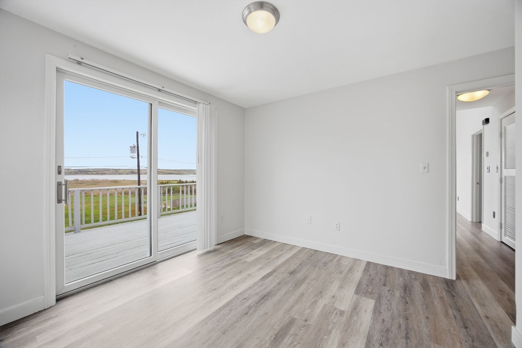 192 Swifts Beach Road Wareham, MA 02571 - Photo 37 of 38 an empty room with wooden floor and windows