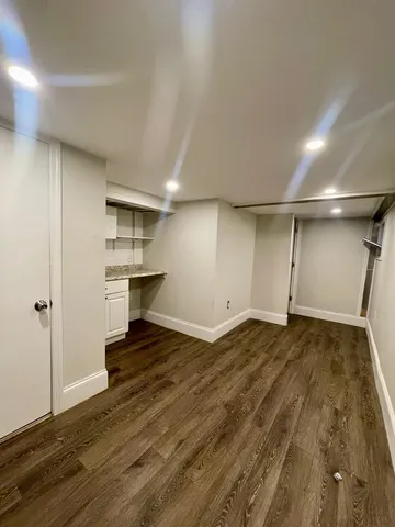 a view of empty room with wooden floor and cabinet