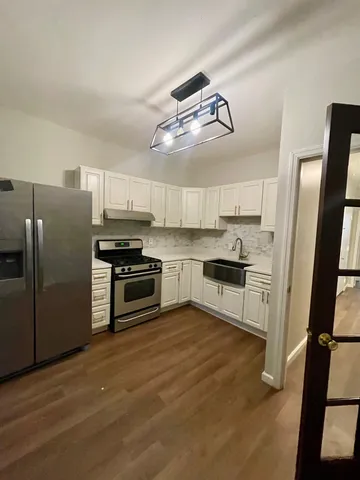 a kitchen with stainless steel appliances a stove a refrigerator and cabinets