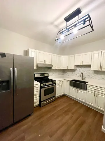 a kitchen with granite countertop a refrigerator stove and sink