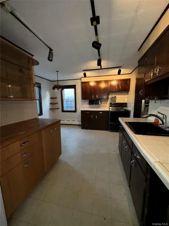 a large kitchen with stainless steel appliances a stove a sink and a microwave