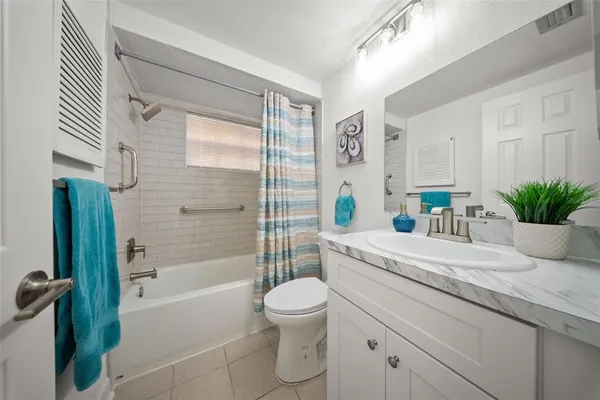 a bathroom with a granite countertop sink a toilet and shower