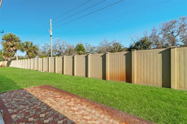 a view of a yard with wooden fence