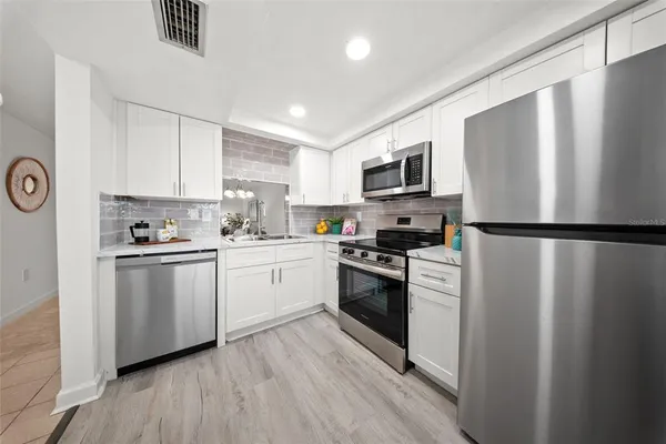 a kitchen with a refrigerator stove and microwave