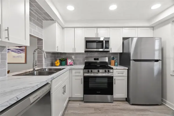 a kitchen with a sink stove and refrigerator