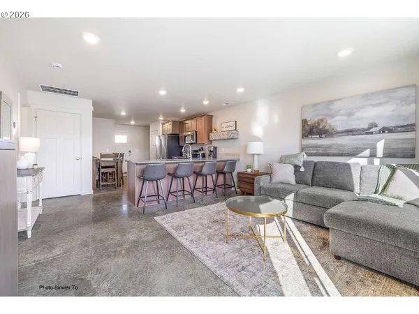 a living room with furniture and a dining table with kitchen view