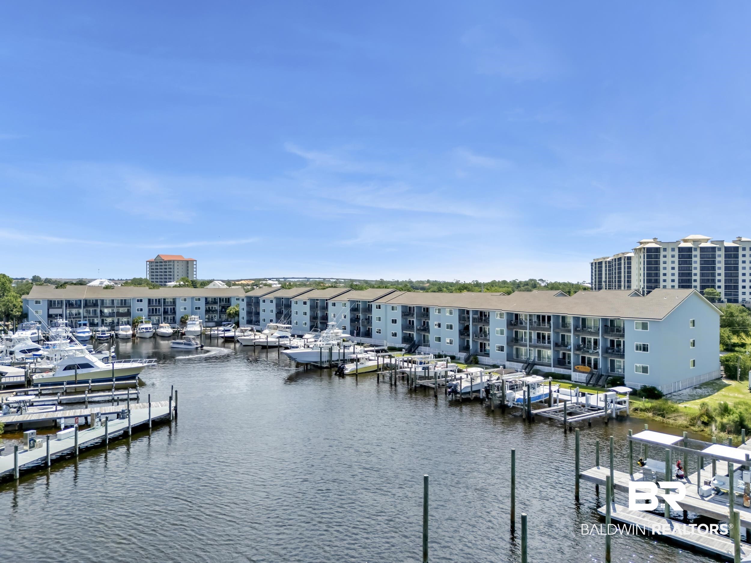14100 River Road, Unit 211 Pensacola, FL 32507 - Photo 48 of 56 Waterfront condominium complex featuring private boat slips, balconies, and a serene marina setting