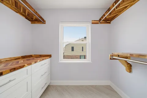 a view of a kitchen with white cabinets and wooden floor