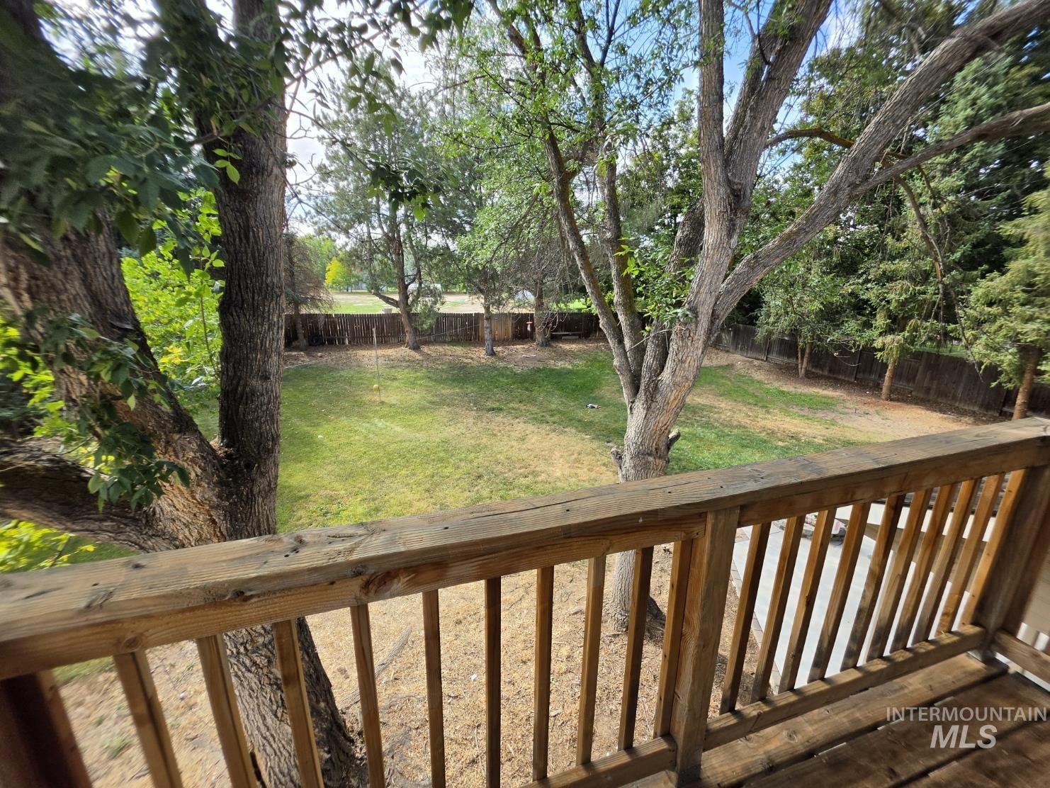 3201 South Riva Ridge Way Boise City, ID 83709 - Photo 23 of 29 Expansive backyard with a manicured lawn, mature trees, and wood fencing