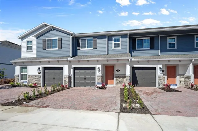a front view of a house with yard and parking