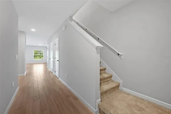 a view of a hallway with wooden floor and staircase