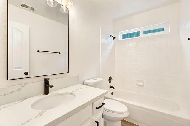 a bathroom with a sink a toilet and a mirror