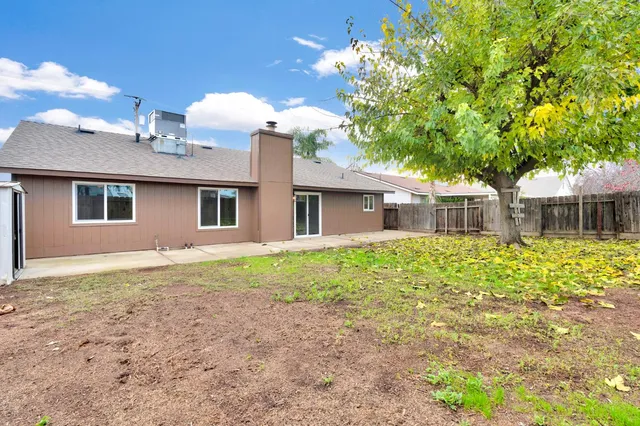 a front view of house with yard and trees around