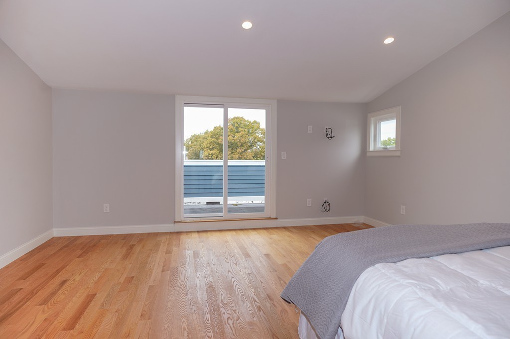 75 Decatur Street, Unit 3 Arlington, MA 02474 - Photo 12 of 20 a view of a bedroom with wooden floor and a window