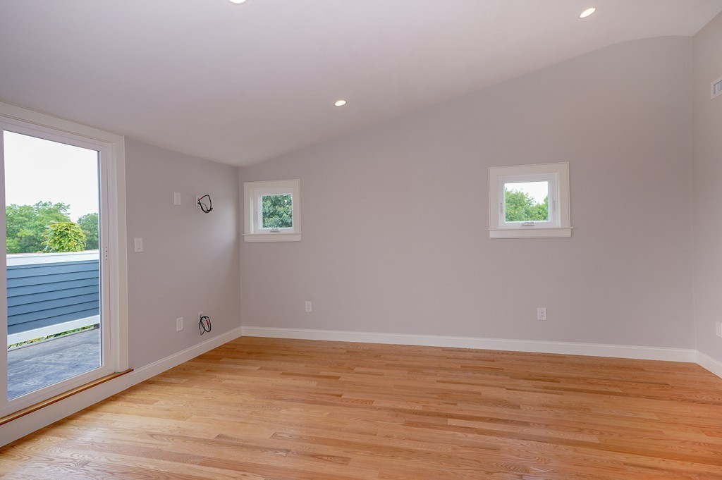 75 Decatur Street, Unit 3 Arlington, MA 02474 - Photo 13 of 20 an empty room with wooden floor and windows