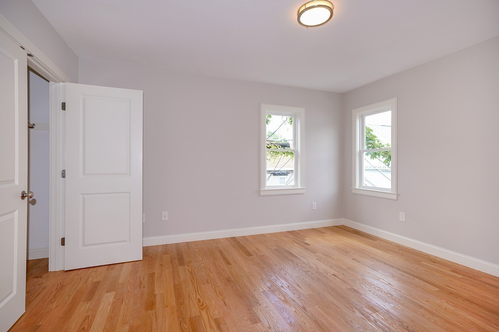 75 Decatur Street, Unit 3 Arlington, MA 02474 - Photo 17 of 20 an empty room with wooden floor and windows