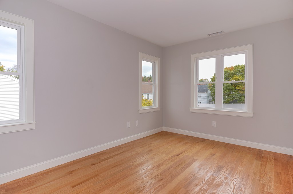 75 Decatur Street, Unit 3 Arlington, MA 02474 - Photo 18 of 20 an empty room with wooden floor and windows
