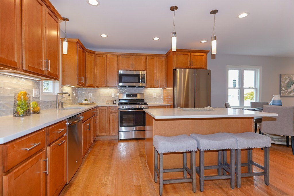 75 Decatur Street, Unit 3 Arlington, MA 02474 - Photo 3 of 20 a kitchen with stainless steel appliances a dining table chairs sink and cabinets
