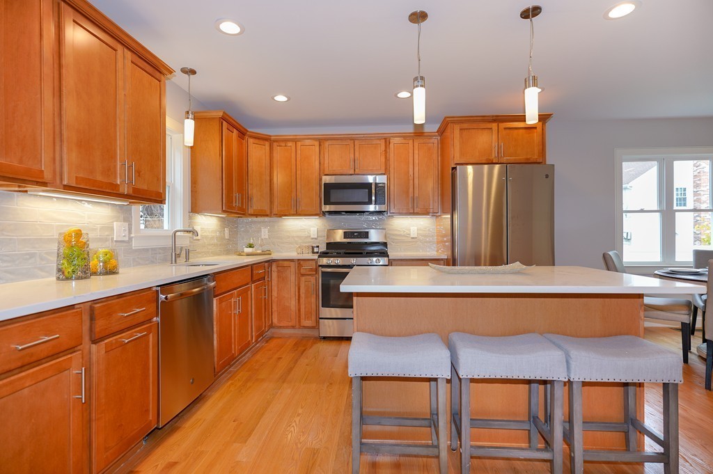 75 Decatur Street, Unit 3 Arlington, MA 02474 - Photo 4 of 20 a kitchen with stainless steel appliances granite countertop a stove top oven a refrigerator a sink and chairs