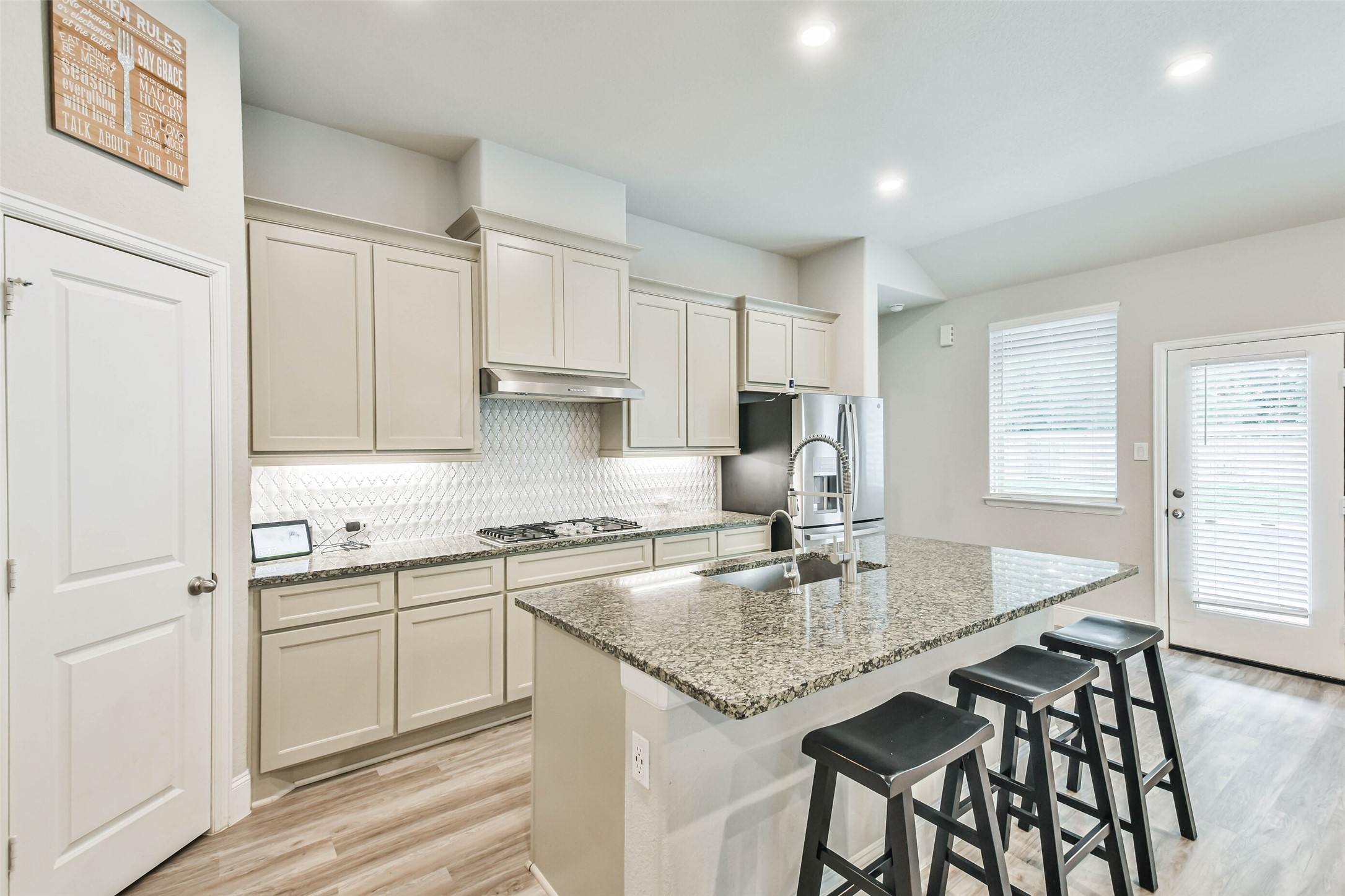 22095 Volante Drive Spring, TX 77386 - Photo 11 of 47 a kitchen with kitchen island granite countertop a table chairs sink and cabinets