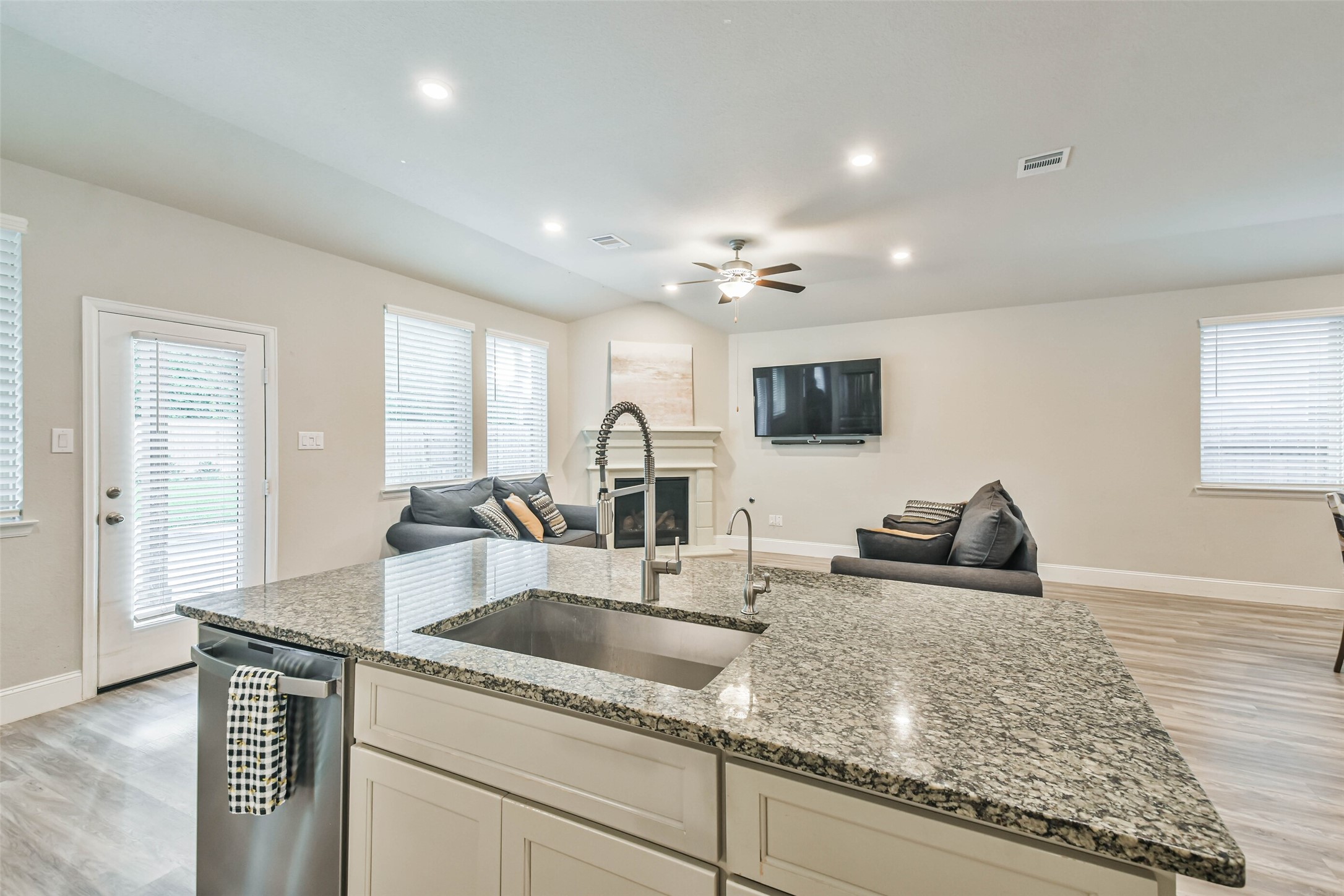 22095 Volante Drive Spring, TX 77386 - Photo 14 of 47 a kitchen with granite countertop a sink and a stove top oven with wooden floor