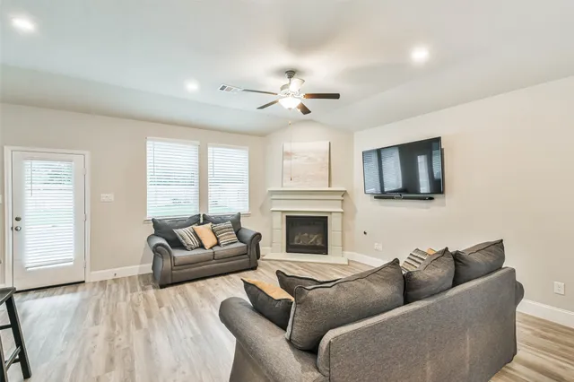 a living room with furniture a fireplace and a flat screen tv