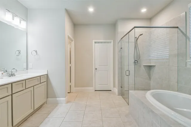 a bathroom with a bathtub shower sink vanity and toilet
