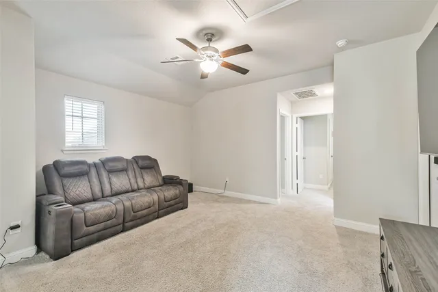 a living room with furniture and a ceiling fan