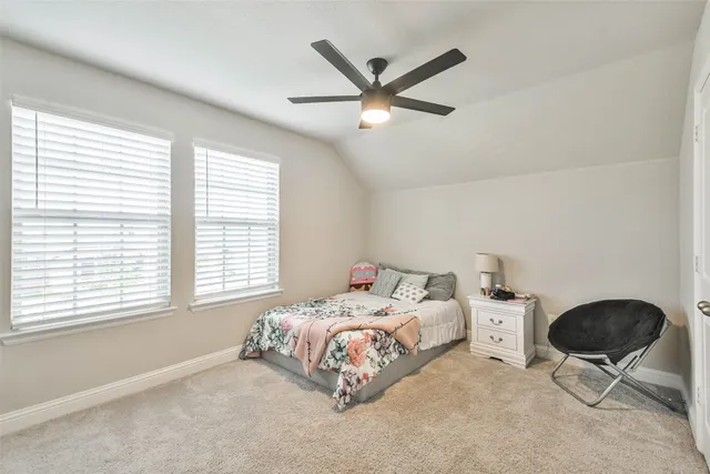a bedroom with a bed a chair and a large window