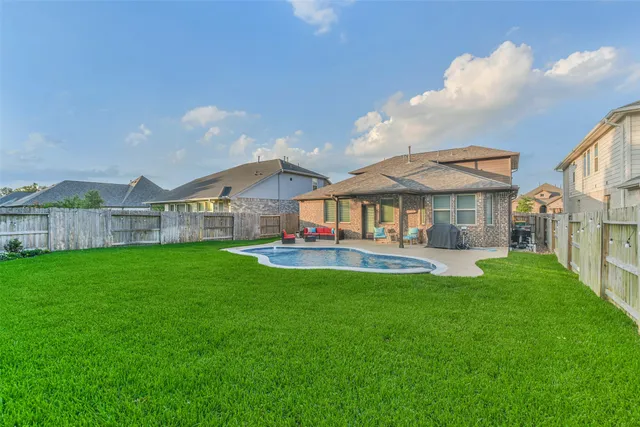 a front view of house with yard barbeque and outdoor seating