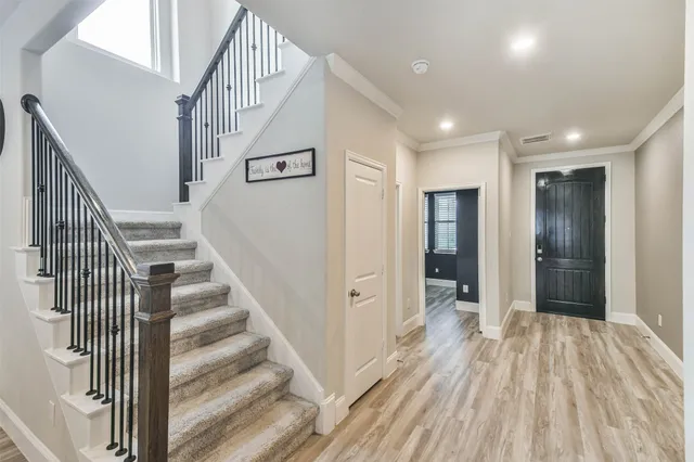 a view of a hallway with wooden floor and entryway