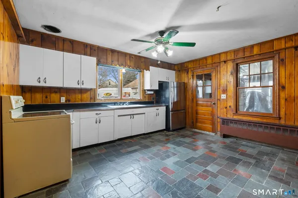 a kitchen with granite countertop a sink cabinets stainless steel appliances and a window