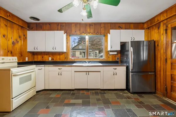 a kitchen with a refrigerator sink and cabinets