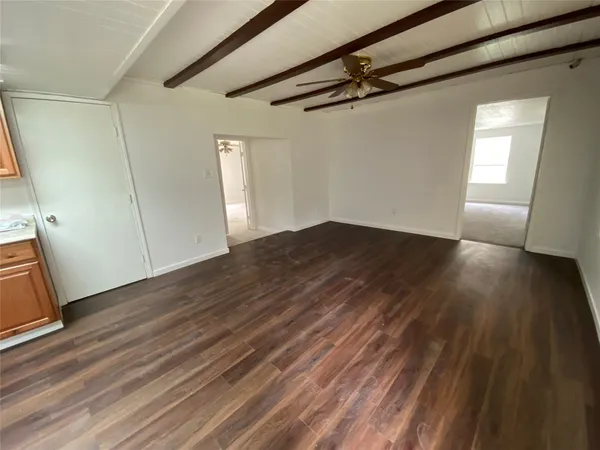 a view of a room with wooden floor and white walls