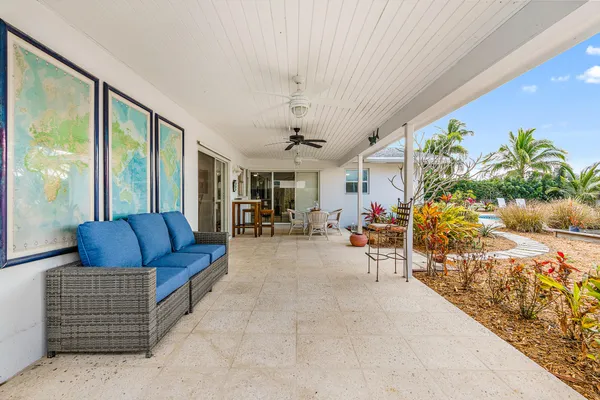 a view of a patio with table and chairs with wooden floor and fence