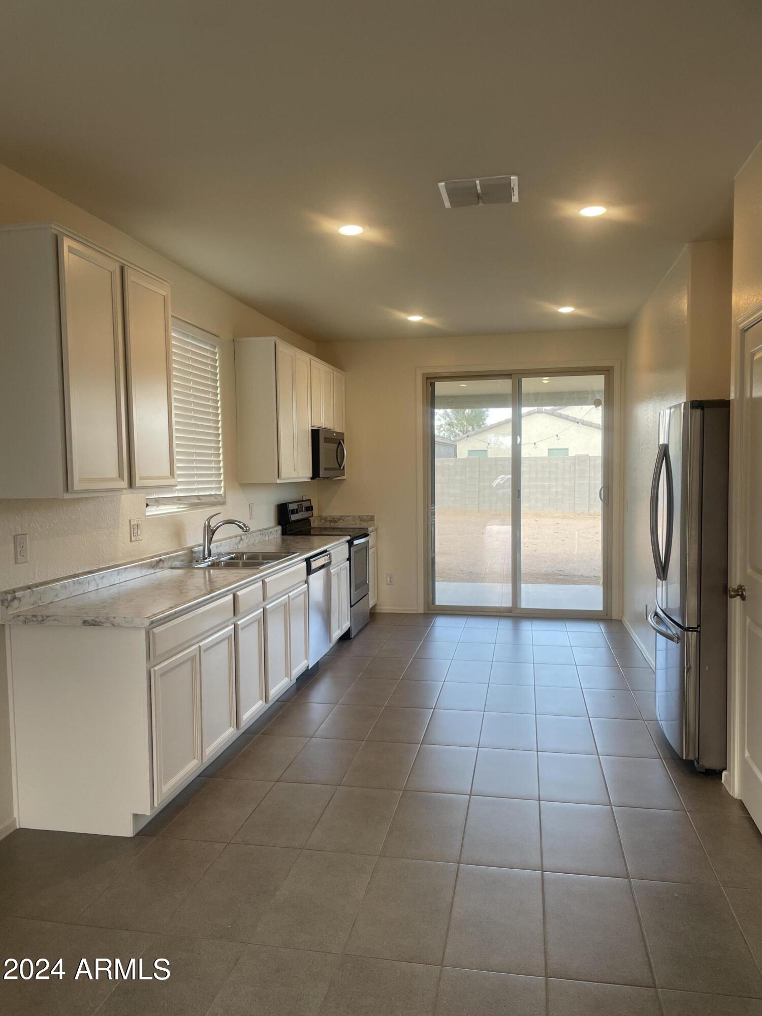 9536 Silo Circle Florence, AZ 85132 - Photo 3 of 12 a large kitchen with a large counter top stainless steel appliances and cabinets