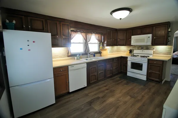 a kitchen with a white stove top oven and refrigerator