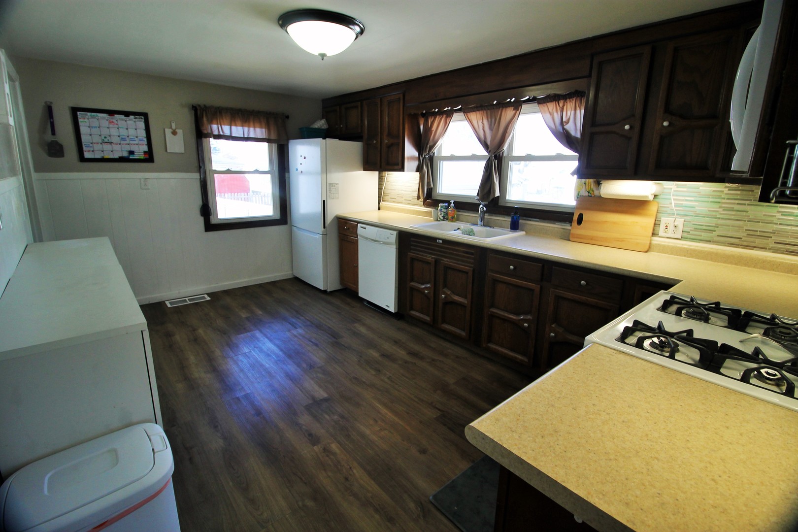 817 South Illinois Street Geneseo, IL 61254 - Photo 10 of 20 a kitchen with a wooden floor a sink a stove cabinets and a large window