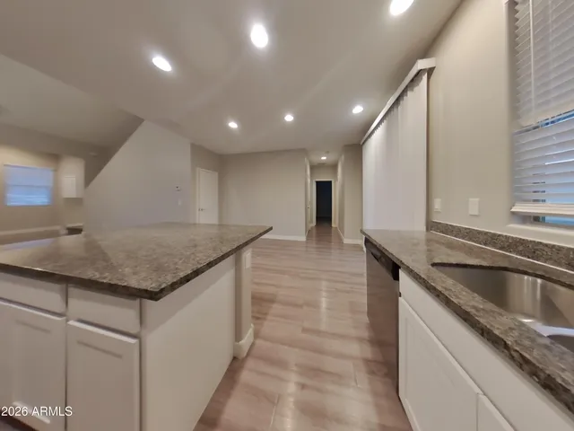 a kitchen with stainless steel appliances granite countertop a sink counter space and a stove
