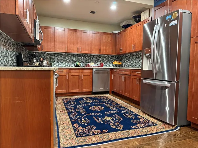 a kitchen with stainless steel appliances granite countertop a refrigerator and a sink