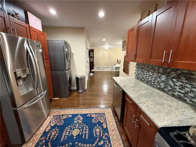 a kitchen with stainless steel appliances granite countertop a refrigerator a stove and a sink