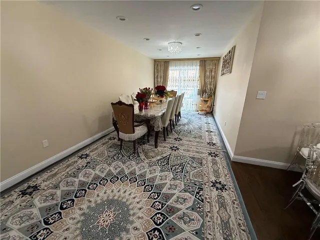 a dining room with a rug and a window