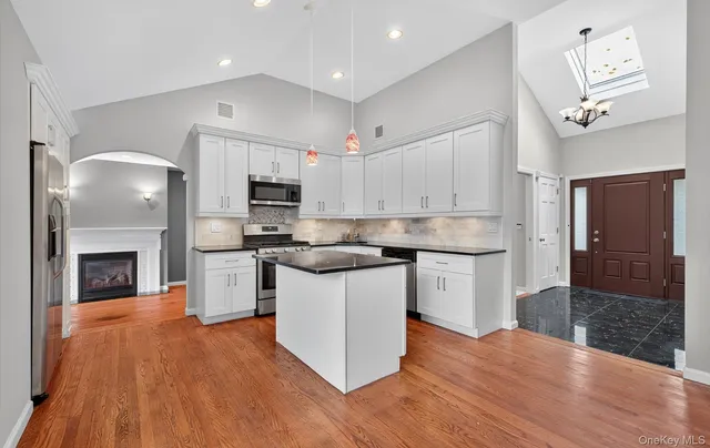 a kitchen with granite countertop a stove top oven a sink and a fireplace