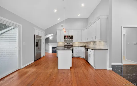 a kitchen with stainless steel appliances granite countertop a refrigerator stove top oven and sink