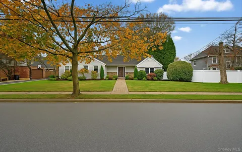 a view of house with a big yard and potted plants