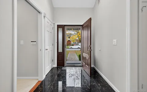 a hallway with dining area wooden floor and front door