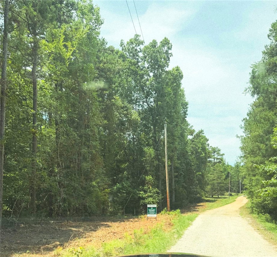 0 Dockside Drive Iva, SC 29655 - Photo 13 of 14 A promising undeveloped lot bordered by mature trees and a gravel road, ready for new construction.