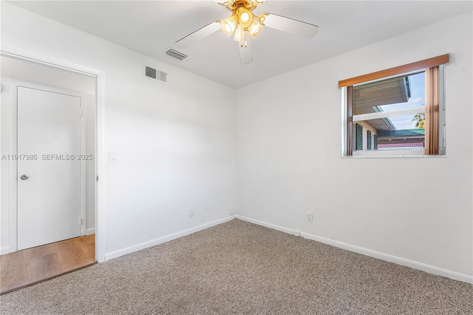 475 Northwest 46th Terrace Plantation, FL 33317 - Photo 26 of 43 an empty room with a window and a chandelier fan
